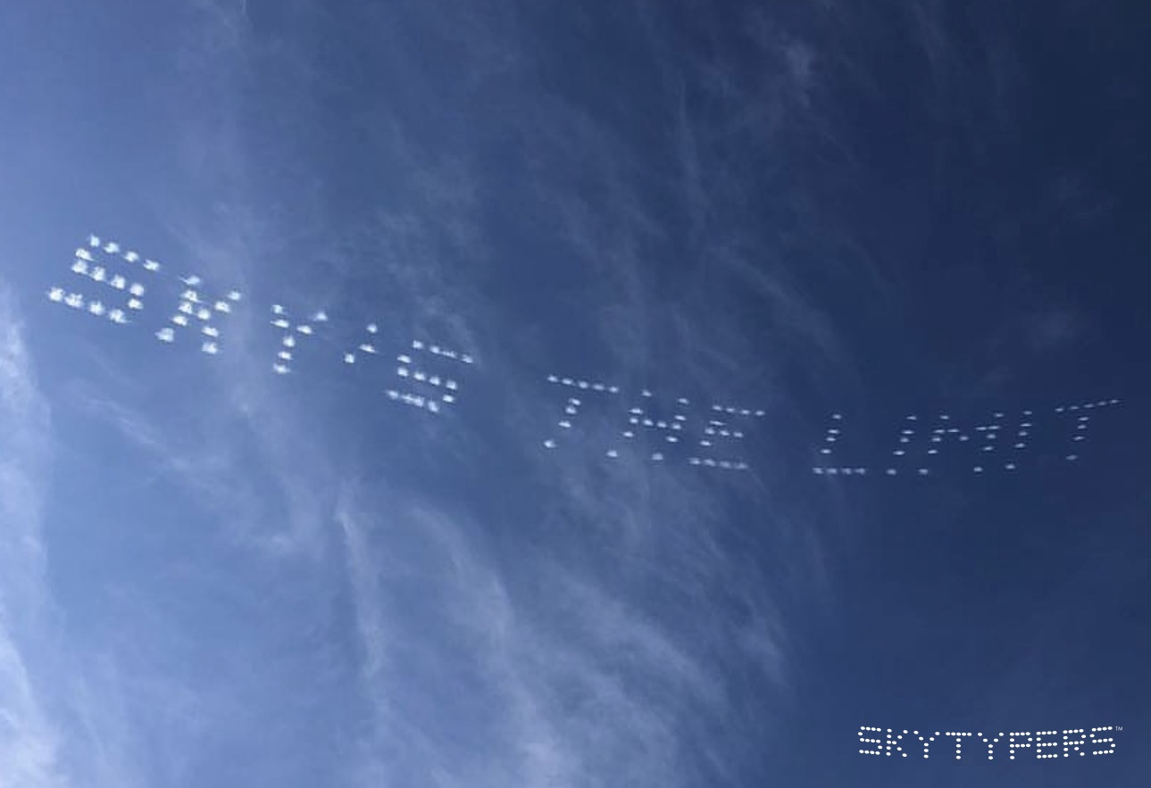 SKY’S THE LIMIT in white dotted skytyping across a blue sky.