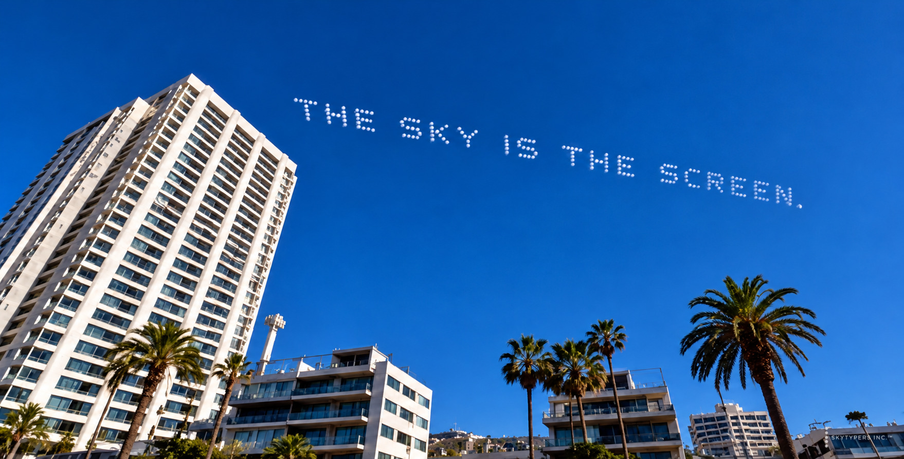 Concept showing THE SKY IS THE SCREEN above city towers and palm trees.