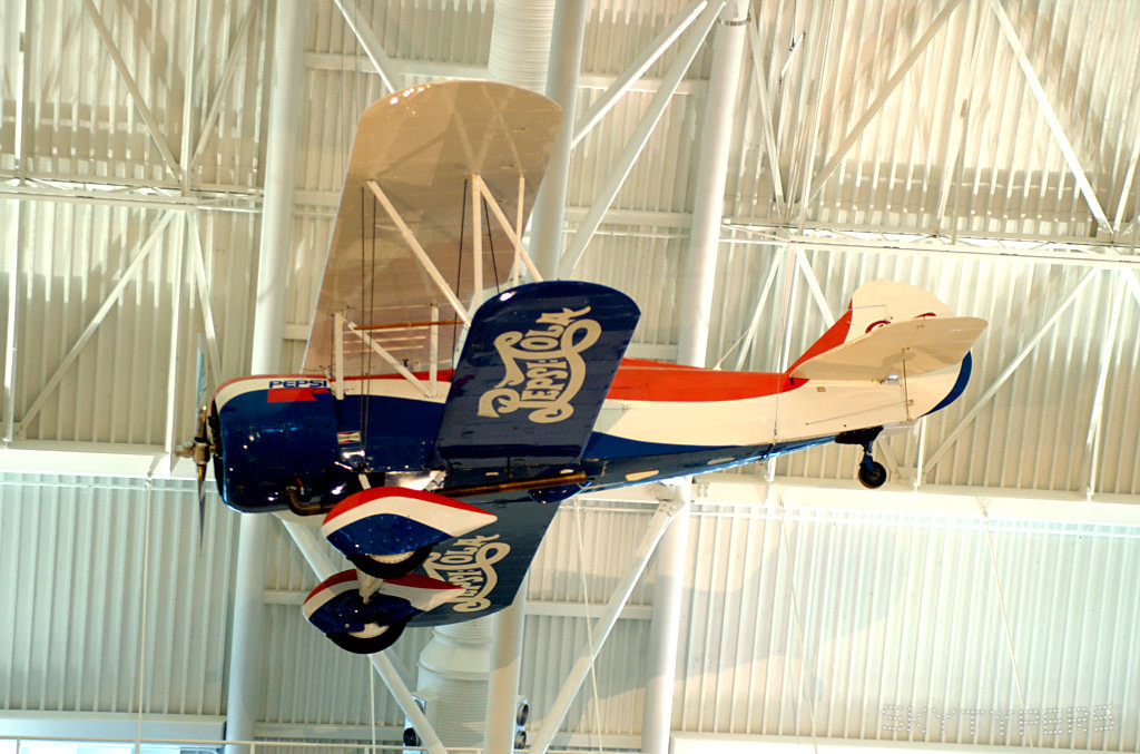 Pepsi-Cola biplane suspended on display.