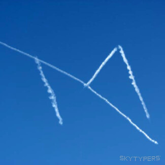 Long white smoke strokes form angular intersecting shapes against a blue sky.