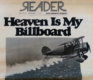 Black and white cover of San Diego's Reader: airplane flying over the city with headline "Heaven Is My Billboard.