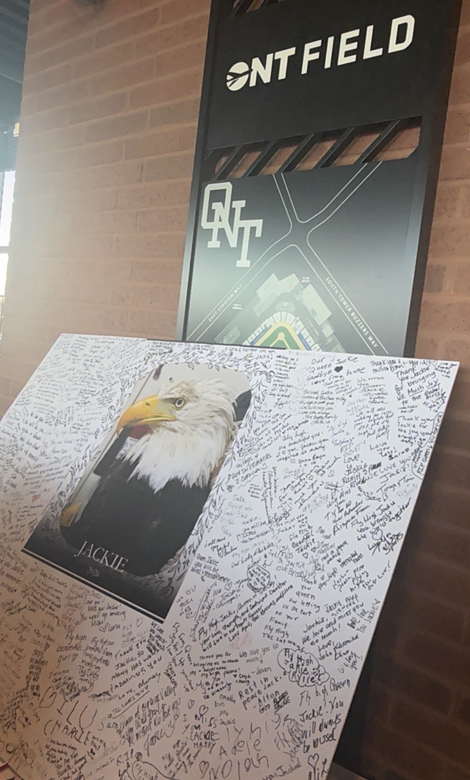 Community messages surround a portrait of Jackie on a memorial board at ONT Field