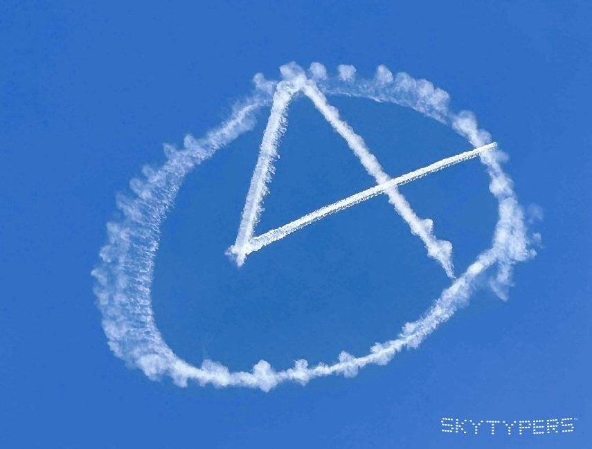A continuous white smoke symbol drawn across a vivid blue sky.